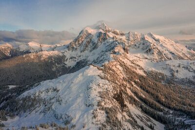 Northwest Aerial Photography Mount Shuksan Afternoon An aerial perspective of Mount Shuksan and the rugged sweep of Shuksan Arm glowing in warm afternoon light. Captured from high above the North Cascades, this...