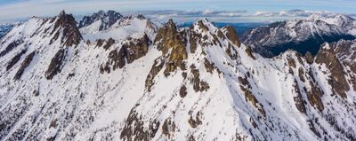 Over the North Cascades Silver Star and Kangaroo Peak Aerial Photography A breathtaking aerial panorama of Kangaroo Ridge near Washington Pass, blanketed in fresh winter snow beneath a crisp blue sky. The dramatic granite peaks and...