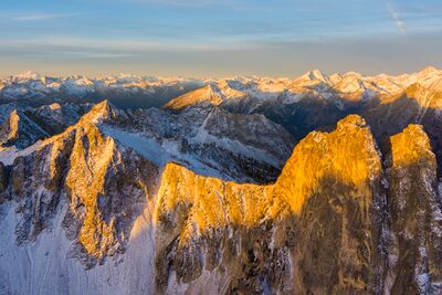 Over the Northwest Early Winters Spires Sunrise Golden morning light ignites the granite spires of Liberty Bell and the surrounding North Cascades peaks in this breathtaking sunrise aerial by Mike Reid...
