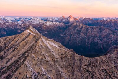 Over the Northwest North Cascades Sunrise Golden Horn A breathtaking aerial sunrise over Golden Horn in Washington’s North Cascades. The first light of dawn brushes the rugged peaks with pink and gold hues,...