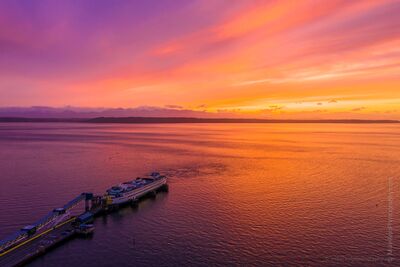Edmonds Ferry Docked At Sunset From Above Mavic Pro 2 A stunning drone aerial captures the Edmonds Ferry Dock glowing beneath a brilliant Pacific Northwest sunset. The sky ignites with shades of magenta, orange,...