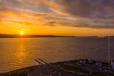 Northwest Aerial Photography Mukilteo Sunset A breathtaking drone aerial captures the Mukilteo waterfront and historic lighthouse glowing under a brilliant Pacific Northwest sunset. The golden light...