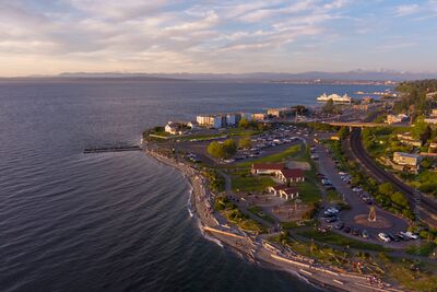 Northwest Aerial Photography Over Mukilteo A high-resolution aerial photograph of Mukilteo Lighthouse Park captures the golden evening light sweeping across the Puget Sound shoreline. The historic...