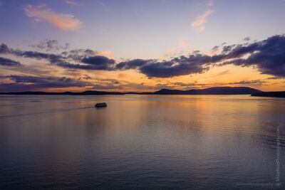 Over San Juan Islands Anacortes Ferry Heading West Sunset Aerial Photography A Washington State ferry sails from Anacortes toward the San Juan Islands beneath a radiant Pacific Northwest sunset. Soft hues of gold, violet, and rose...