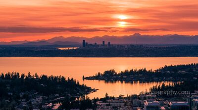 Bellevue Lake Washington and Seattle Sunset Mood Aerial sunset view from Bellevue, Washington, looking west across Meydenbauer Bay, Medina, and Lake Washington toward the Seattle skyline. Warm orange light...