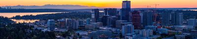 Bellevue Skyline at Sunset with Seattle and the Olympic Mountains A sweeping aerial panorama of downtown Bellevue, Washington, at sunset, with Lake Washington, the distant Seattle skyline, and the Olympic Mountains stretching...
