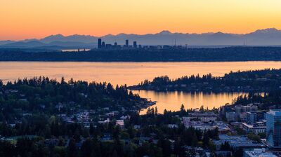 Bellevue and Seattle Skyline at Sunset Across Lake Washington A sweeping aerial view from Bellevue, Washington, looking west across Lake Washington toward the Seattle skyline and the Olympic Mountains at sunset. Warm...