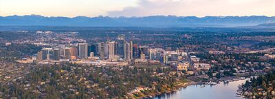 Downtown Bellevue Skyline and Meydenbauer Bay with Cascade Mountains A sweeping telephoto aerial view of downtown Bellevue, Washington, rising above the waterfront neighborhoods of Meydenbauer Bay on Lake Washington. The city's...