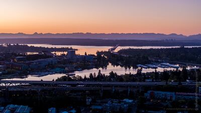 Sunrise Over the I-5 Bridge Toward Lake Washington Aerial sunrise view across Seattle with the I-5 Ship Canal Bridge in the foreground, Portage Bay and the University of Washington beyond, and the SR 520...