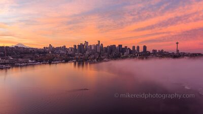 Aerial Seattle Lake Union Under a Cloud A breathtaking sunrise unfolds over Seattle as a soft layer of fog drifts across Lake Union. The Space Needle stands tall on the right, while Mount Rainier...
