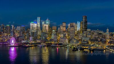 Over Seattle Blue Hour Skyline and Wheel Seattle’s downtown skyline glows under a deep blue evening sky, with the iconic Seattle Great Wheel casting vibrant reflections across Elliott Bay. From this...
