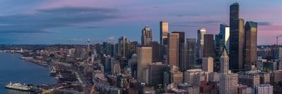 Over Seattle Downtown Above Pioneer Square A peaceful aerial view of Seattle’s downtown waterfront as dawn breaks over Elliott Bay. The city awakens under soft pastel hues of purple and gold, with the...