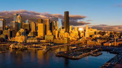 Over Seattle Downtown Golden Light A glowing aerial portrait of Seattle’s downtown skyline basking in the golden light of sunset. The city’s iconic high-rises — including the Columbia Center and...