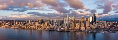 Over Seattle Golden Light City Panorama A sweeping aerial panorama of the Seattle skyline glowing under the last light of day. The golden hues of sunset illuminate the city’s modern architecture —...