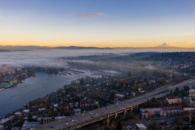 Montlake, Seattle and Mount Rainier Through Morning Mist An aerial view across Seattle’s Montlake and University District area toward Mount Rainier, with low mist drifting through the neighborhoods and waterways...
