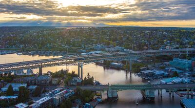 Evening Light Over Seattle’s Ship Canal Bridges Aerial view of Seattle at evening, looking across the Lake Washington Ship Canal with the I-5 Ship Canal Bridge and the University Bridge crossing the water...