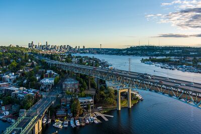Seattle Skyline and Ship Canal Bridges from Above An aerial view across Seattle’s Lake Washington Ship Canal, with the I-5 Ship Canal Bridge and University Bridge crossing the water below. Gas Works Park lies...