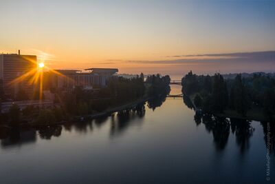 Sunrise Over the Montlake Bridge and UW Early sunrise light glows over Seattle’s Montlake Cut, with the Montlake Bridge centered in the distance and the University of Washington campus and medical...