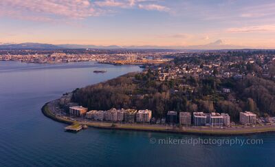 Alki Point and Mount Rainier at Sunset, Seattle An aerial view over Alki Point in West Seattle at sunset, with Puget Sound wrapping around the shoreline and Mount Rainier visible in the distance. Soft evening...