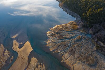 Northwest Aerial Photography River Abstracts With Clouds.jpg An aerial view of braided river channels and sediment patterns flowing into Baker Lake in Washington State. Turquoise water winds through pale sand and gravel...