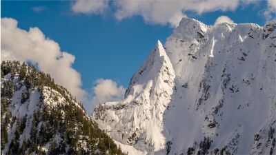 Mountain Loop Highway Snowy Peaks – North Cascades Winter Landscape Photography A dramatic winter view along Washington’s Mountain Loop Highway, featuring rugged snow-covered peaks under brilliant blue skies. Captured by Mike Reid, this...