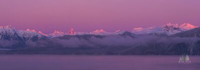 Petersburg Alaska Sunset Coast Range Glow.jpeg Pink alpenglow illuminates the snow-covered peaks of Alaska’s Coast Range across the water from Petersburg. Low clouds drift along the forested lower slopes...