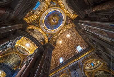 Columns and Dome Inside St. Peter's Basilica A dramatic upward view inside St. Peter's Basilica in Vatican City, where massive marble columns and richly decorated arches rise toward one of the basilica’s...