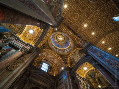 Looking Up Inside St. Peter's Basilica A dramatic upward view inside St. Peter's Basilica in Vatican City, where massive marble piers, gilded coffers, mosaics, and richly decorated domes rise...
