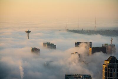 Space Needle and Downtown Seattle Above the Morning Fog Warm sunrise light settles over Seattle as dense morning fog fills the city, leaving the Space Needle and the tops of downtown buildings floating above the...