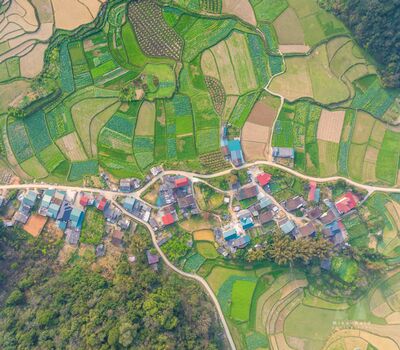 Patchwork Village and Farmland in Phong Nam, Vietnam A straight-down aerial view of a rural village surrounded by cultivated fields in Phong Nam, Cao Bằng Province, northern Vietnam. Narrow roads weave between...