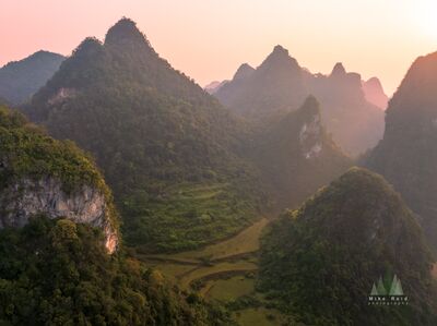 Phong Nam Karst Mountains in Soft Morning Light Soft morning light and haze settle between the steep limestone karst peaks of Phong Nam in Cao Bằng Province, northern Vietnam. Forested ridges rise sharply...
